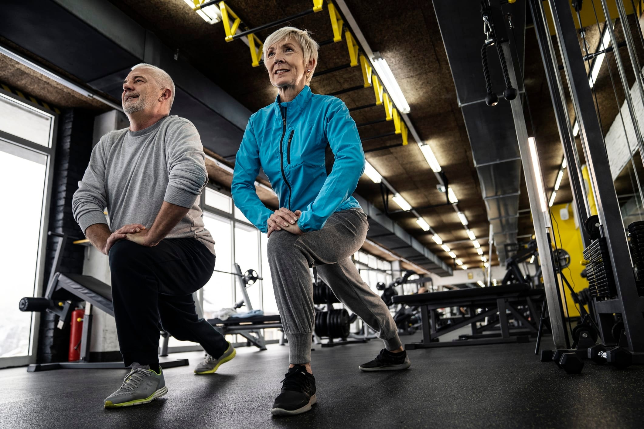 Senior man and woman exercising in a gym.