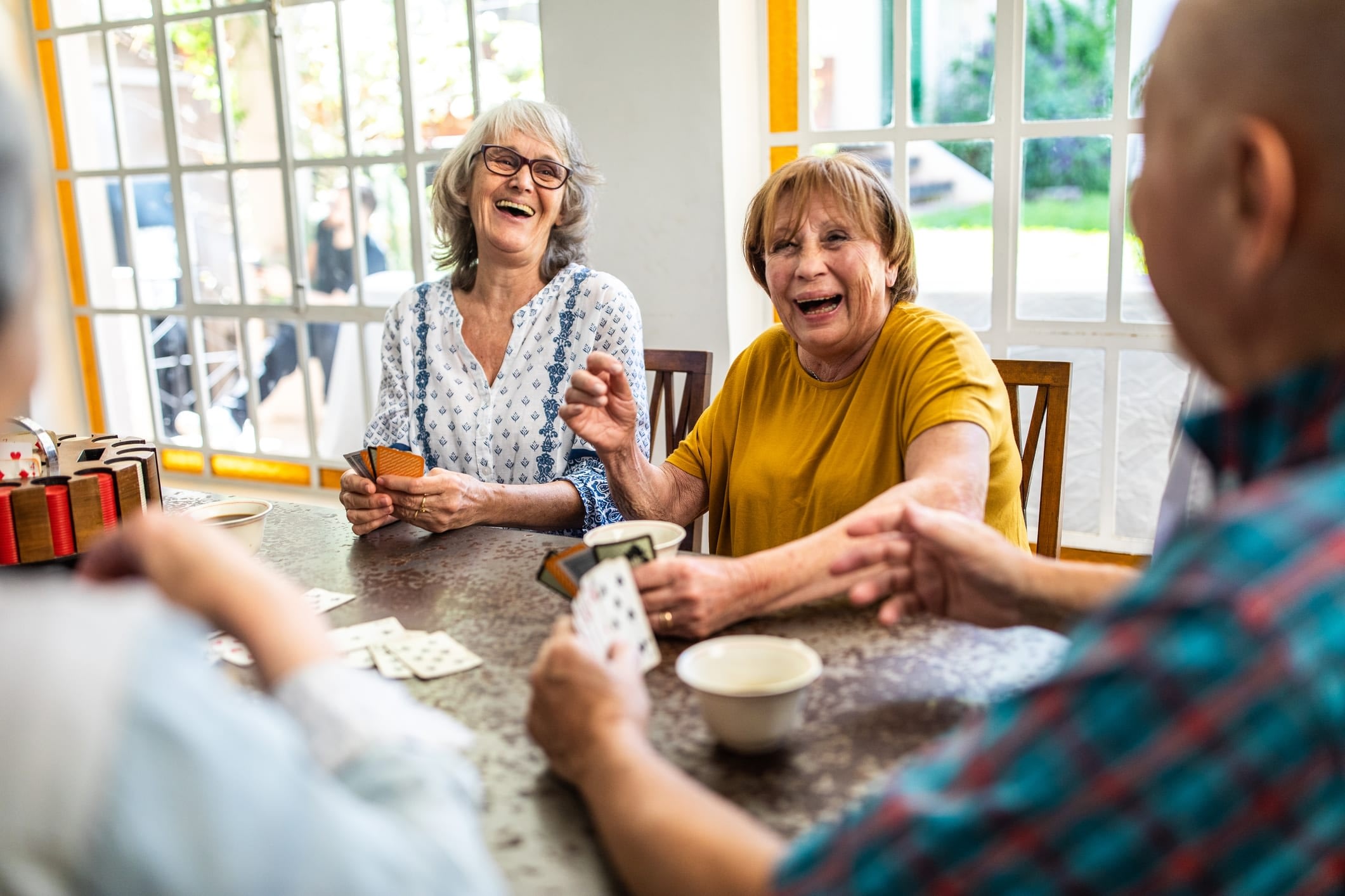 Group of seniors playing cards at a table.