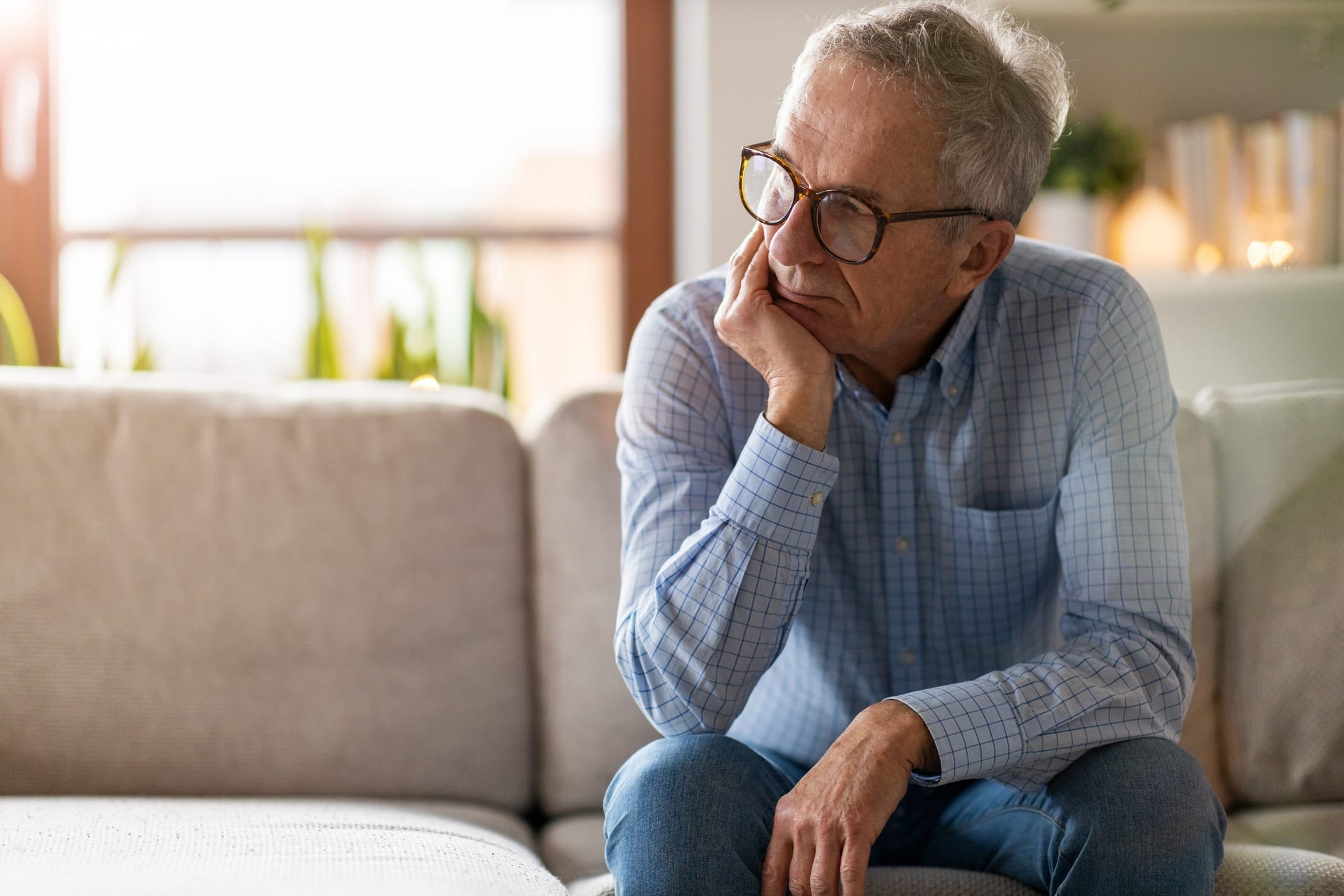 Worried senior sitting alone in his home.
