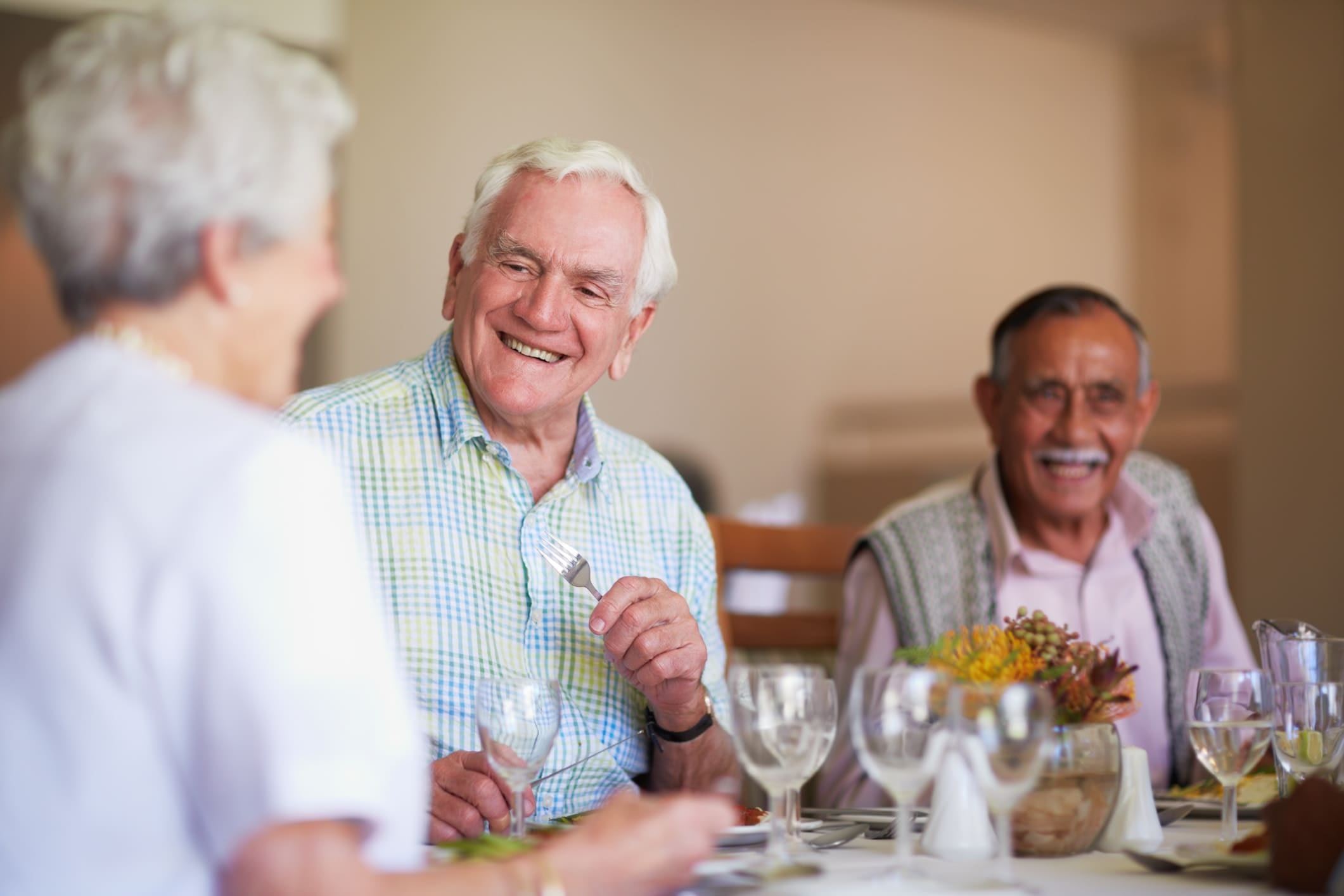 A group of seniors smiling while having lunch together