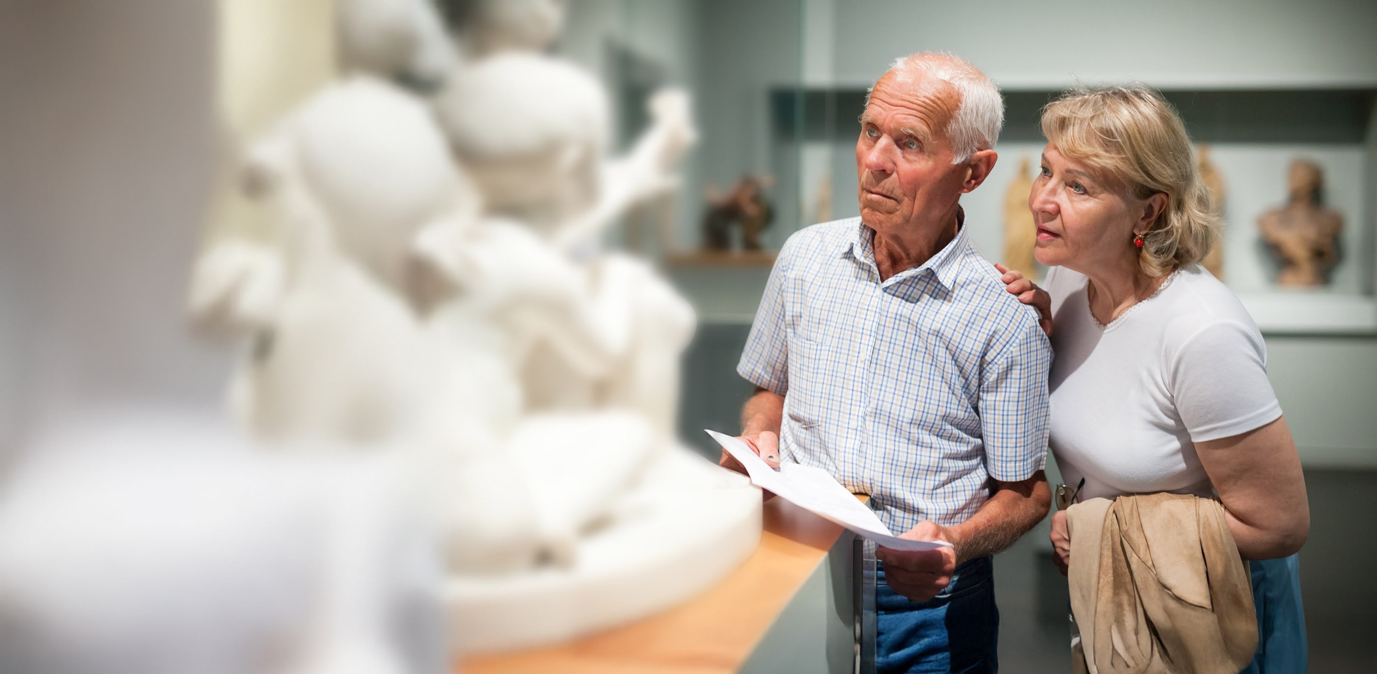 Older couple viewing sculpture in museum gallery