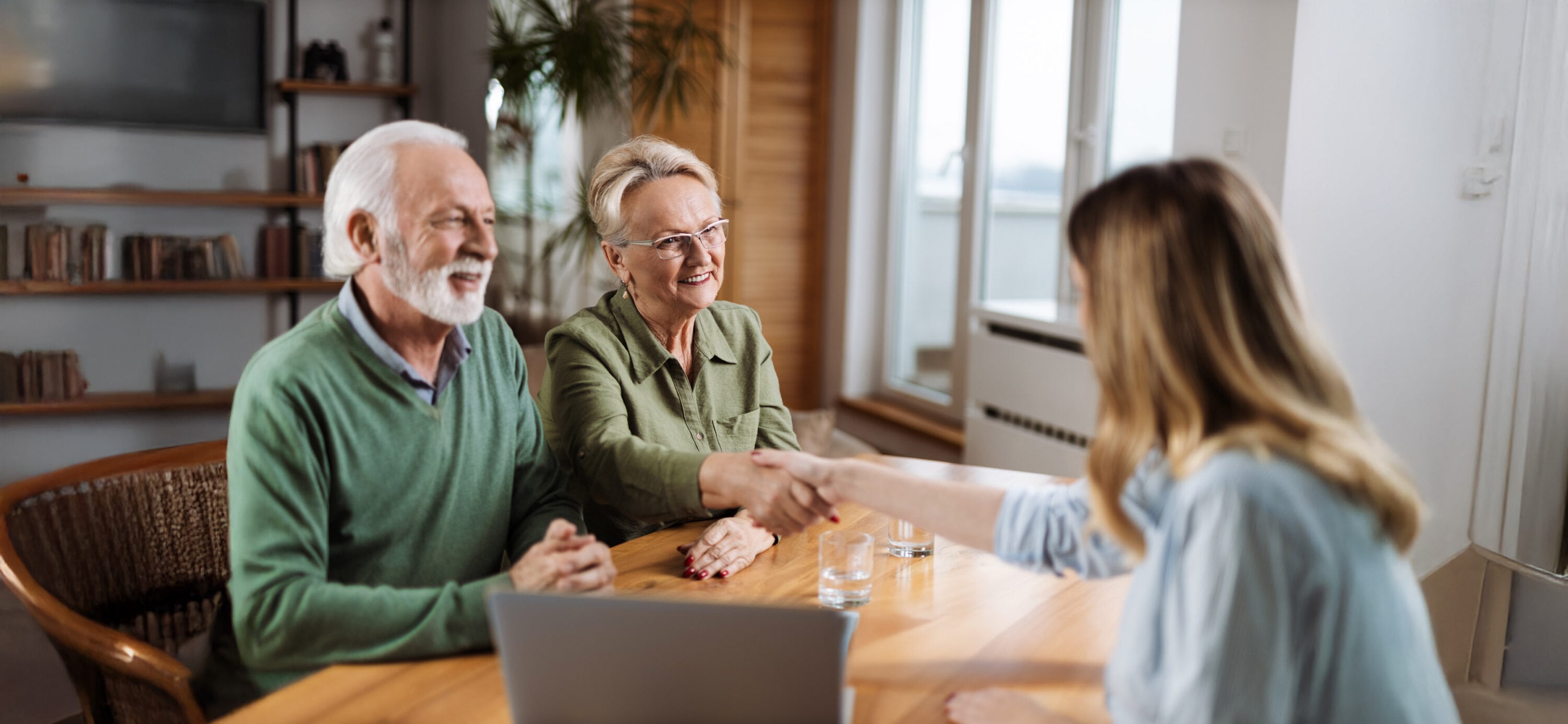 Senior couple shaking hands with financial advisor