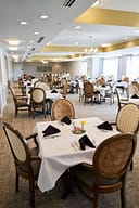 Elegant dining hall with round tables and chandeliers