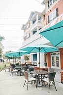 Outdoor patio seating with teal umbrellas and balconies