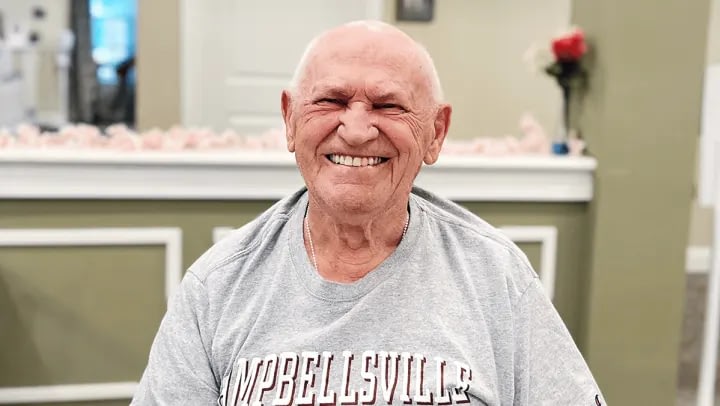 Smiling elderly man sitting indoors